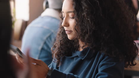hermosa joven usando un teléfono inteligente en un café enviando mensajes de texto compartiendo mensajes en las redes sociales disfrutando de la tecnología móvil