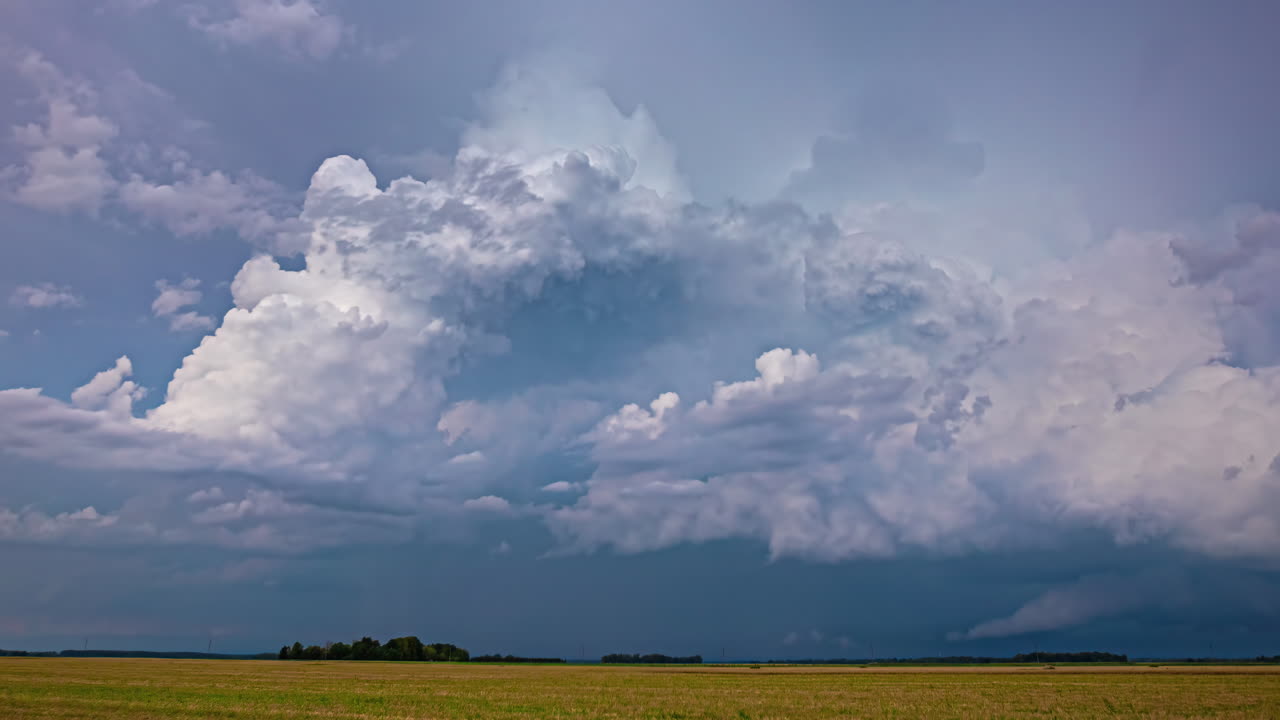 fotografía cinematográfica de un tractor trabajando en un campo con nubes dramáticas en el cielo