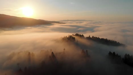 Luftaufnahme-Eines-Wolkenverhangenen-Berggipfels-Bei-Sonnenaufgang-Mit-Goldenem-Licht