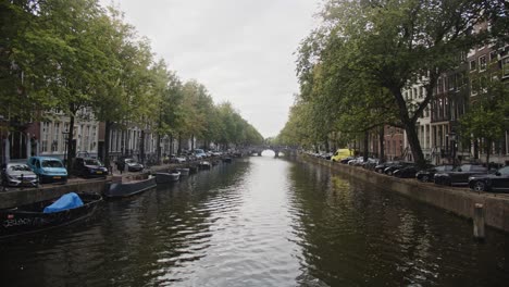 wide view of beautiful and peaceful amsterdam canal on a cloudy day