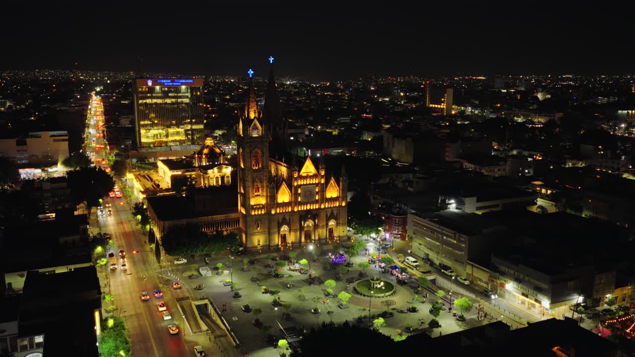 Stunning aerial footage of Templo Expiatorio in Guadalajara glowing under night lights. The cityscape and bustling streets create a lively and enchanting urban ambiance