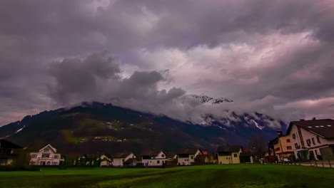 Zeitrafferaufnahme-Von-Dunklen-Wolken-über-Häusern-An-Den-Ausläufern-Der-Bergkette-Während-Der-Abendzeit