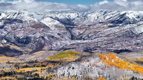 kebler pasa aéreo cinematográfico dron tarde crested butte gunnison colorado las estaciones chocan temprano en el otoño árbol de aspen rojo amarillo bosque naranja invierno primera nieve en polvo pico de montaña rocosa pan hacia adelante