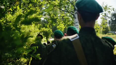 army young soldiers marching in the forest in green beret in military camouflage close up