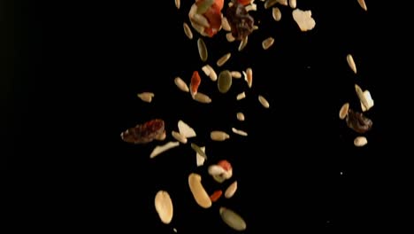 frutas secas que caen contra un fondo negro 4k