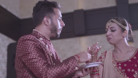 Indian-Newly-Married-Couple-Feeding-Each-Other-A-Little-Bit-Of-Cake