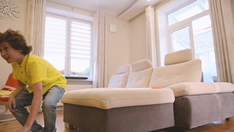 blond boy playing with his dog in the living room