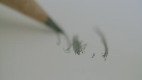 macro shot of a pencil scribbling some lines into a notebook