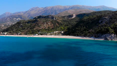 playa paraíso en el fondo de colinas y montañas bañadas por agua de mar azul celeste en albania
