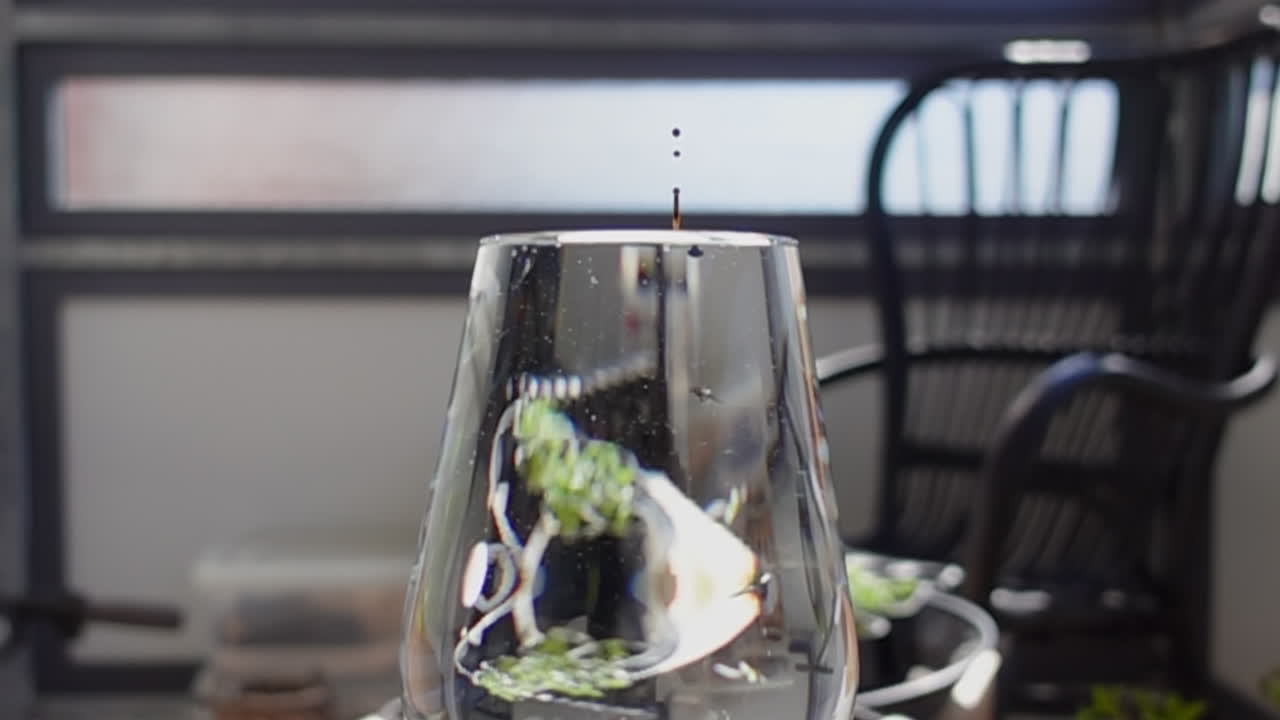 gota de líquido de color que cae en un vaso lleno de agua