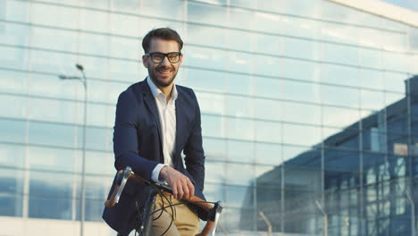 retrato de un hombre atractivo con gafas y sentado en su bicicleta