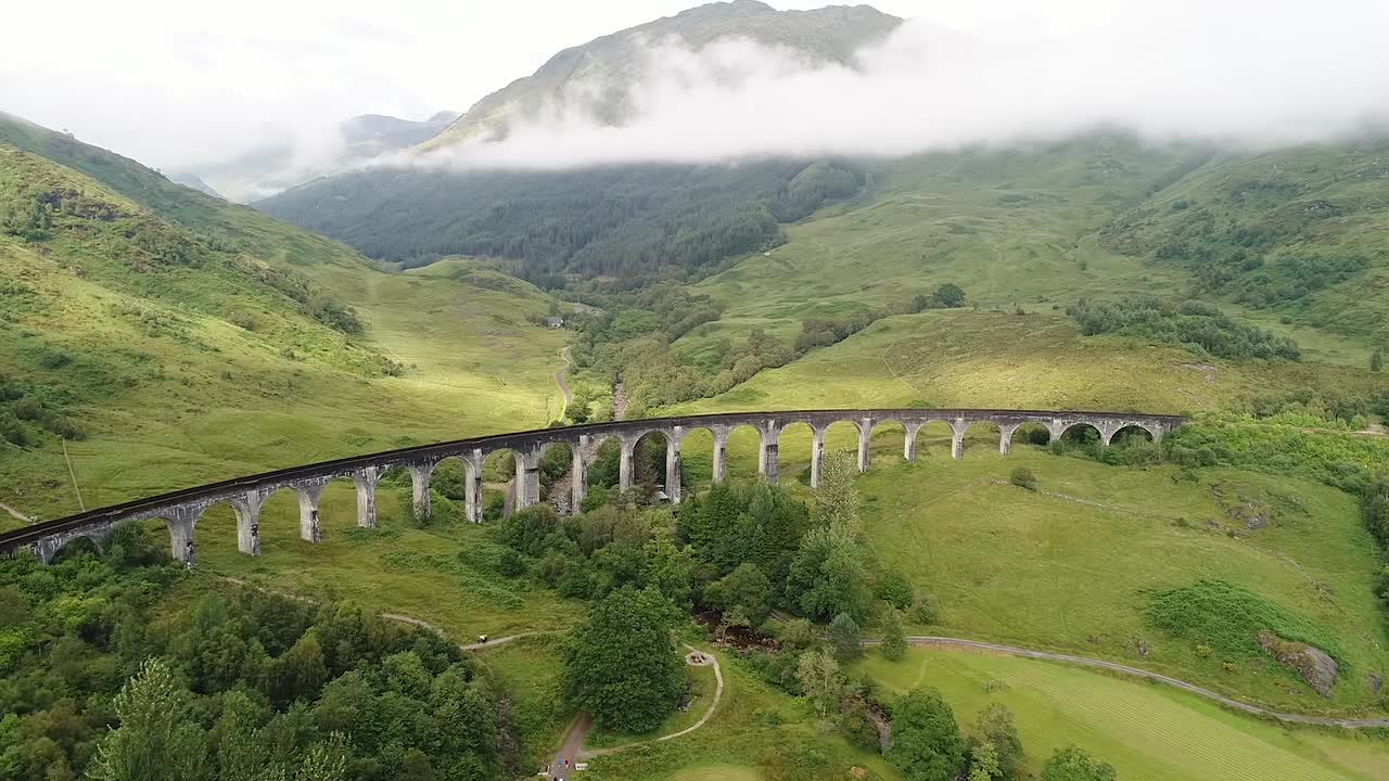 The glenfinnan viaduct is an old bridge crossed by the iconic steam train called jacobite. The scenic valley has been used as a location in several films