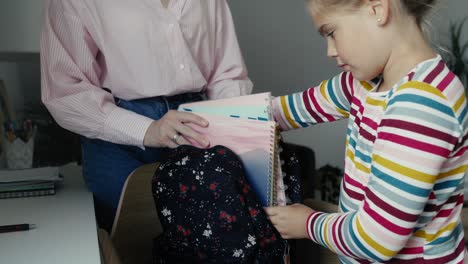 caucasian woman helping her daughter to prepare for school