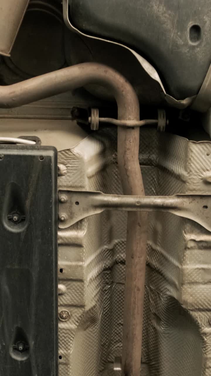 Detailed Pan Up View of a Car's Undercarriage and Exhaust System