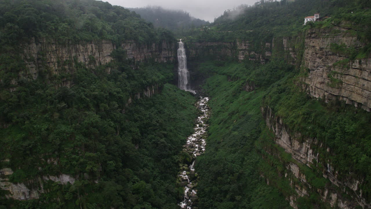 alta cascada idílica en la selva amazónica toma aérea, inclinación hacia abajo toma a la corriente del río