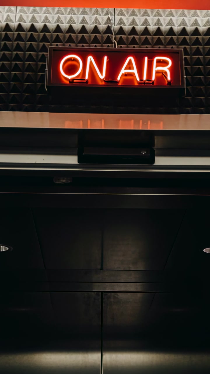 Vertical video: Opening sliding doors, sensor detecting motion at studio, revealing red ON AIR sign