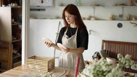 A-red-haired-potter-girl-lays-out-her-products-from-a-wooden-box