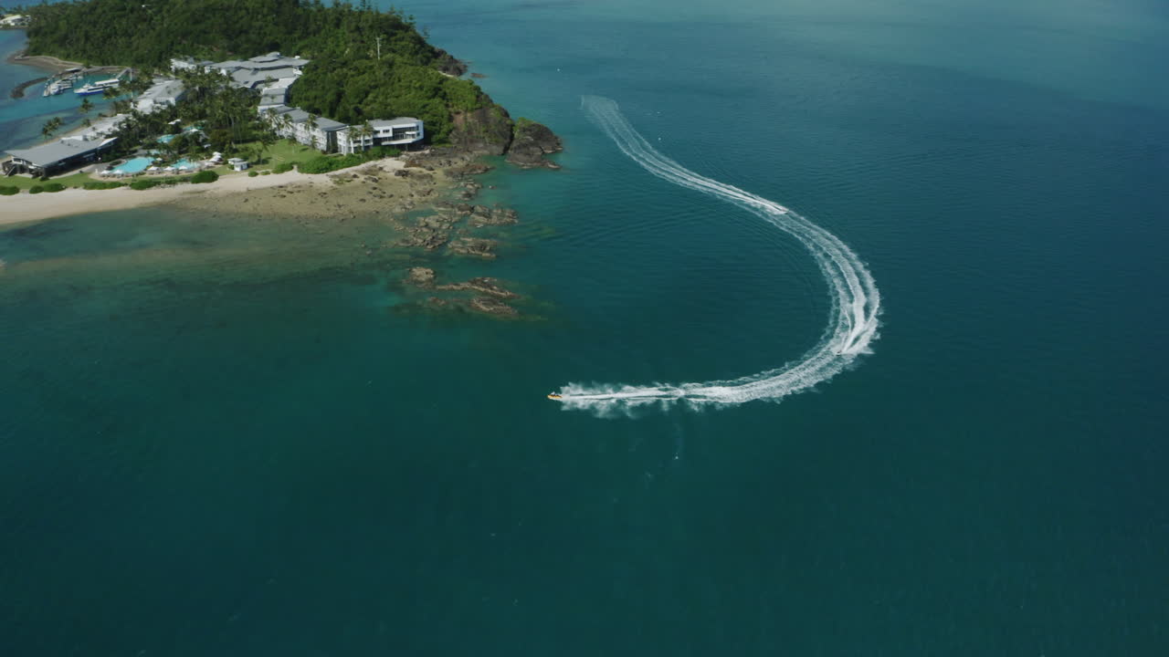 열대 섬 옆 바다에서 제트 스키를 타는 사람들