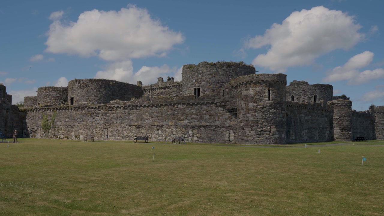 Castello di Beaumaris in un tranquillo paesaggio gallese, con antiche mura in pietra, imponenti torri, erba verde e vegetazione naturale, che cattura il carattere senza tempo di questo storico punto di riferimento di Anglesey