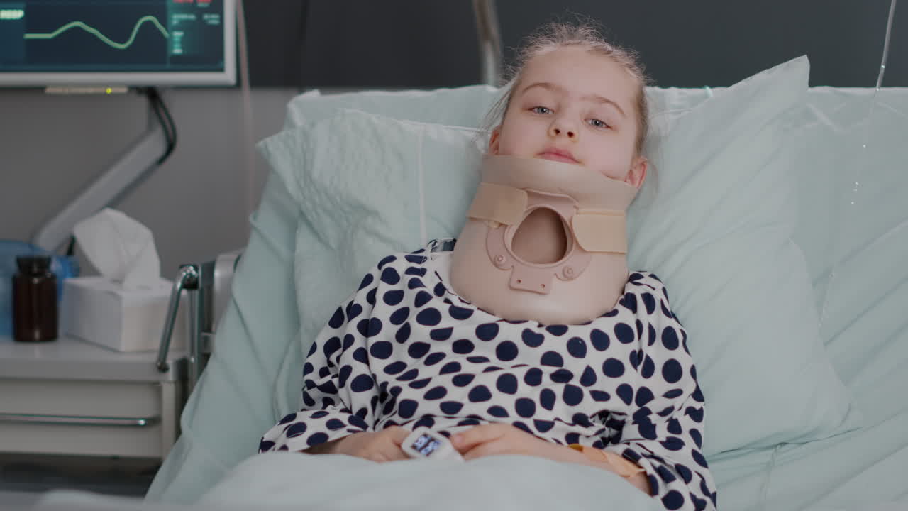 Portrait of hospitalized sick little child resting in bed wearing medical neck cervical collar