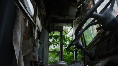 pull out shot of an abandoned trucks rotting interior