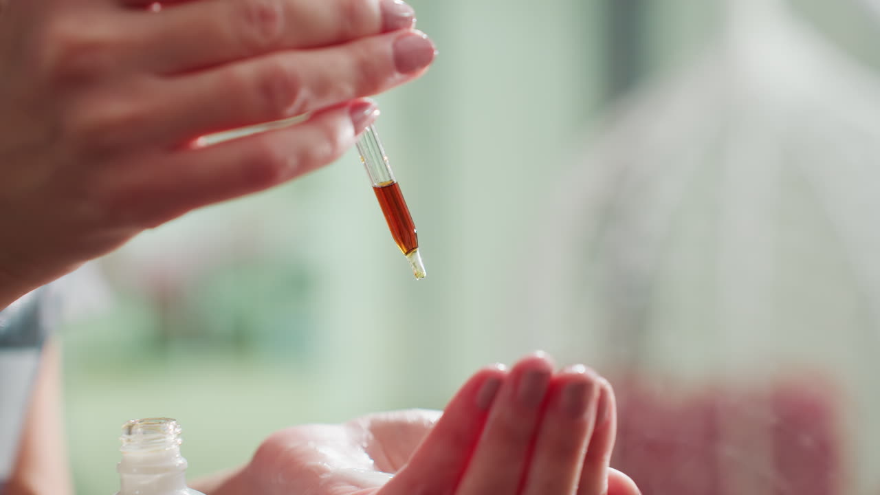 proceso de curación delicado, manos administrando medicina herbal con delicadeza, un toque suave aplicando tintura para la recuperación, manos suaves aplicando tintura medicinal de color ámbar para promover la curación y el confort