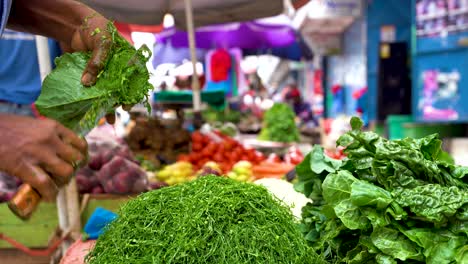 man chopping green vegetables in a grocery shop