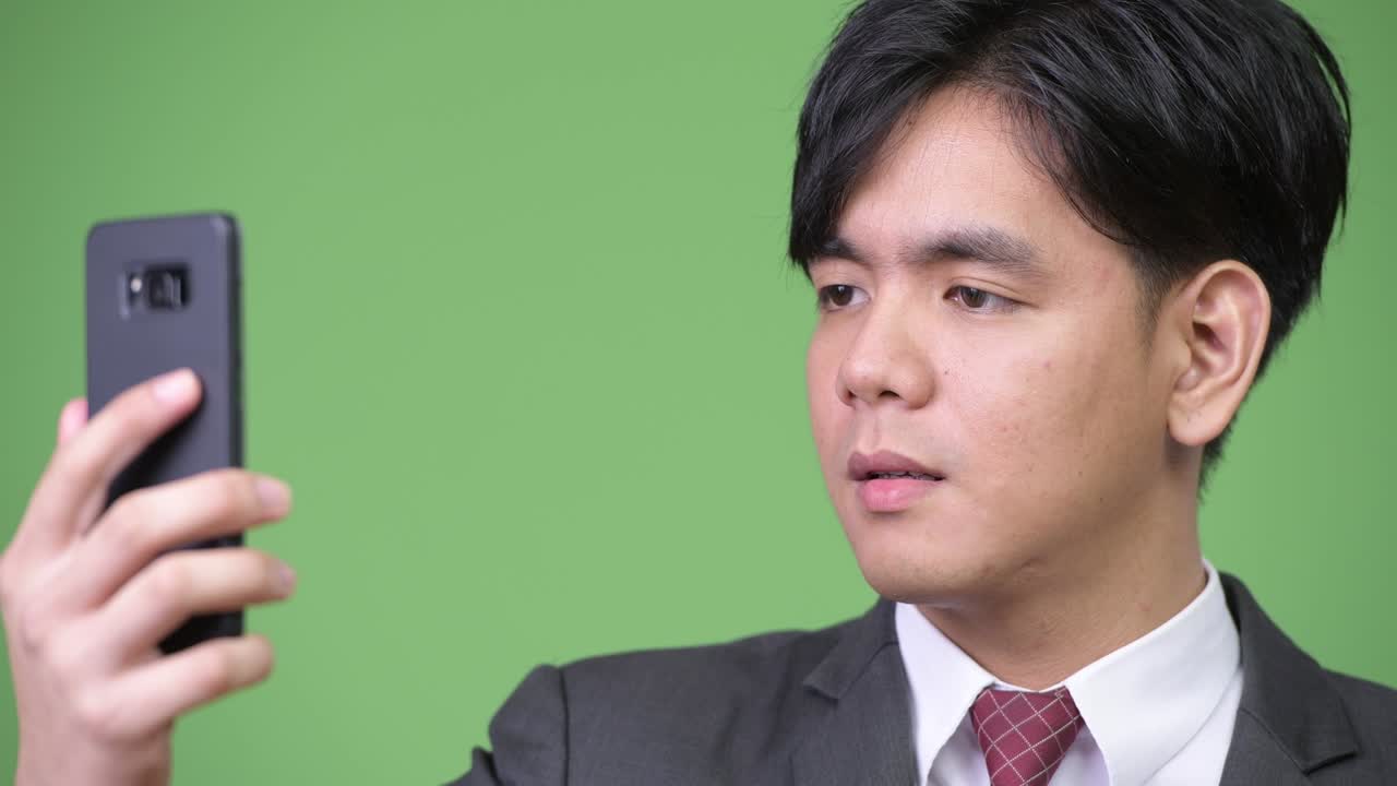 휴대전화를 사용하는 젊은 잘생긴 아시아 사업가