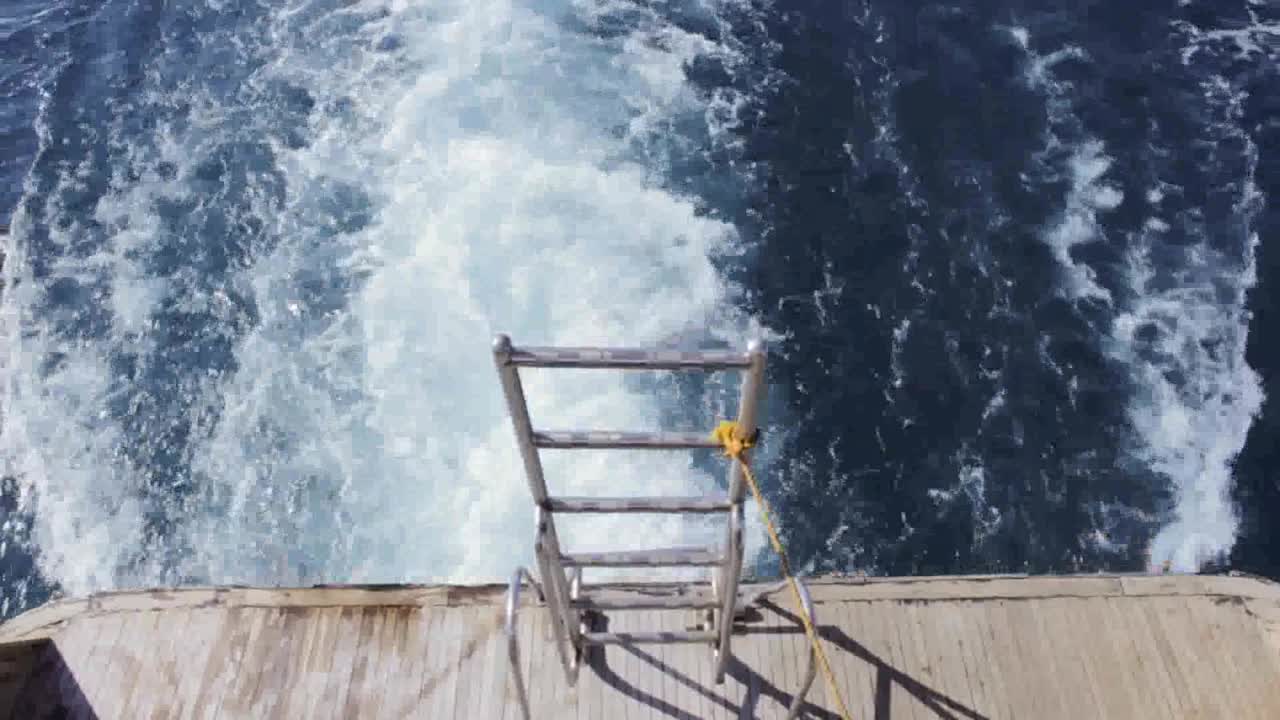 Wasserspritzer hinter einem Boot mit Treppe in Ägypten, Reise im Roten Meer.