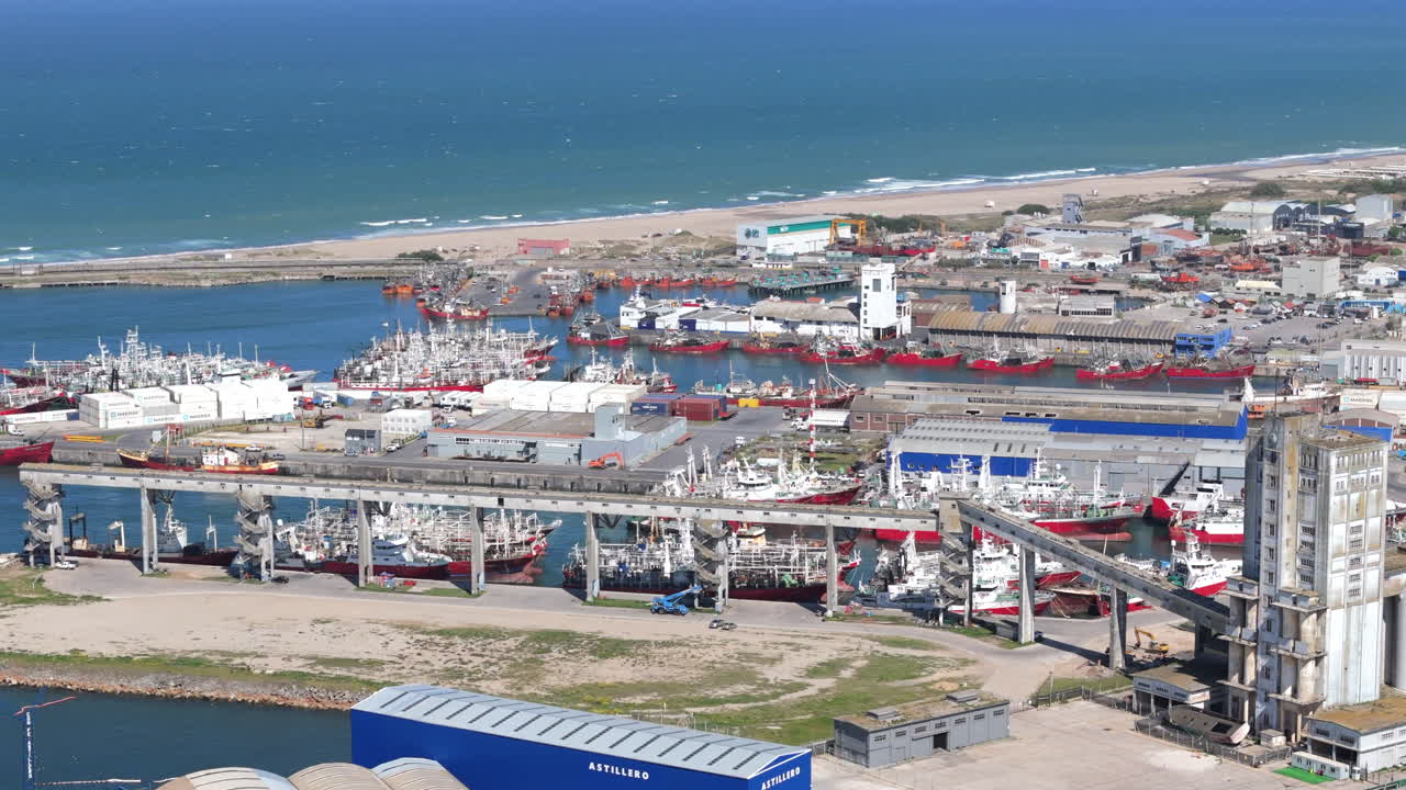 Aerial view of a bustling fishing Port of Mar del Plata with boats and a lively coastal scene, Argentina.