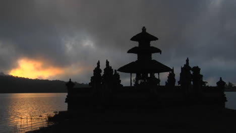 a balinese temple overlooks reflections in a lake 1