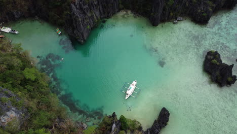 tiro inclinado de un barco anclado en una playa de arena, el nido, palawan