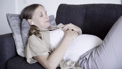 relaxed young pregnant woman listening to music