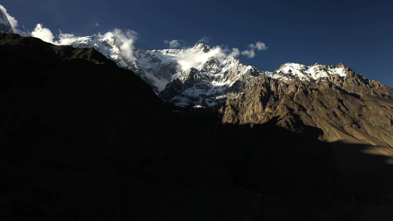 toma dramática de drones del pico tupopdan, conos de passu en hunza pakistán, picos montañosos cubiertos de nieve con acantilados empinados, tiro aéreo panorámico alto y ancho