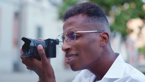 close-up of a man with glasses holding a camera