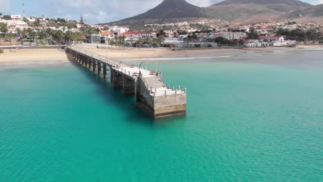 Antena-Dando-Vueltas-Sobre-El-Muelle-En-Aguas-Turquesas-Del-Mar,-Madeira