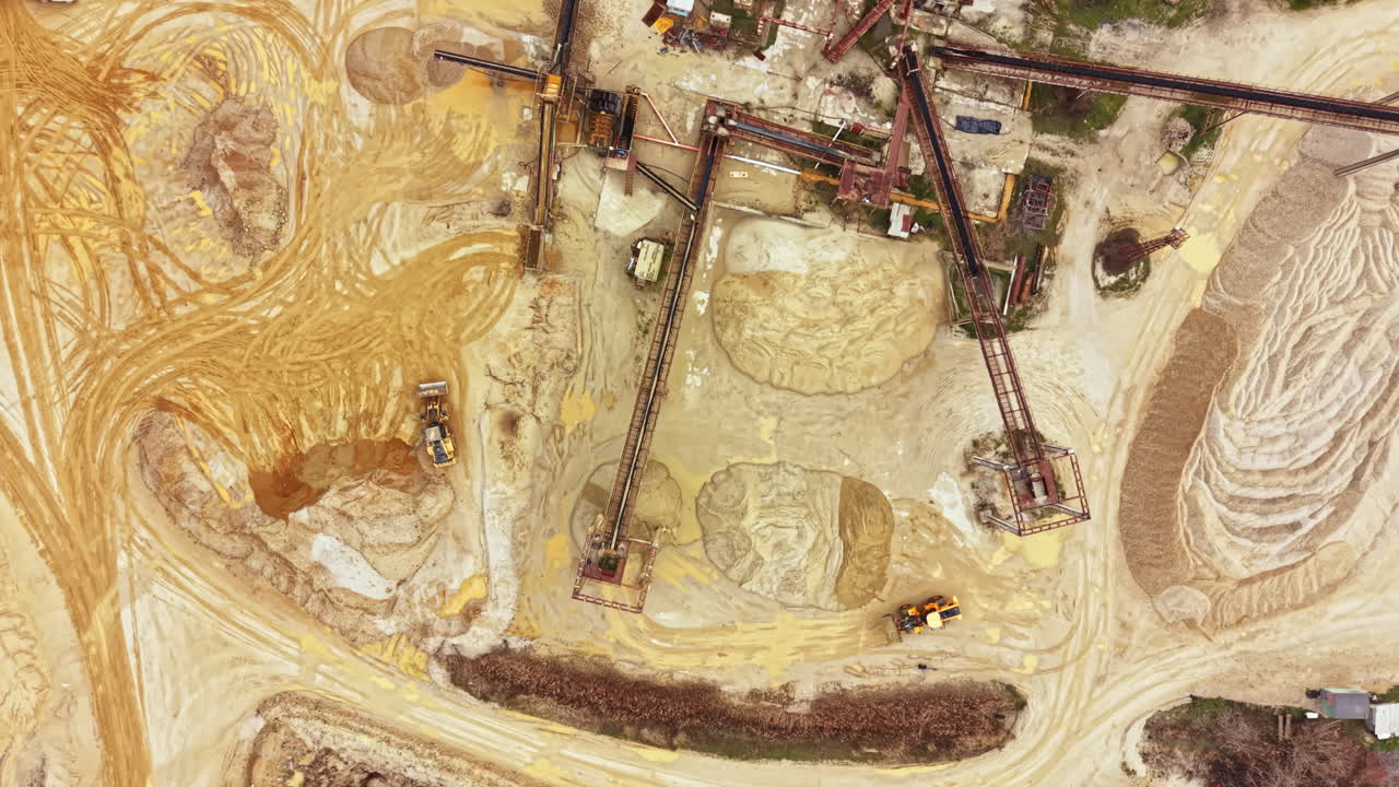Construction site shows heavy machinery and terrain at a mining location during daylight hours