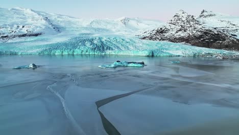 floating icebergs in fjallsarlon glacier lagoon in south iceland - aerial drone shot