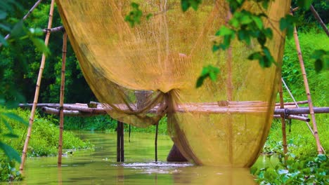 view of large traditional fishing net trap on over river in bangladesh