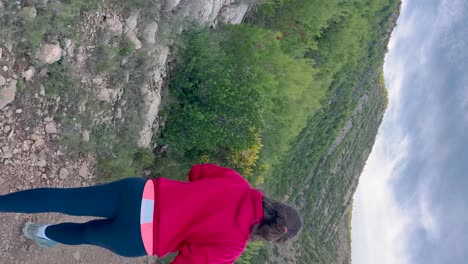 vertical: mujer caminando por senderos junto al mar mediterráneo