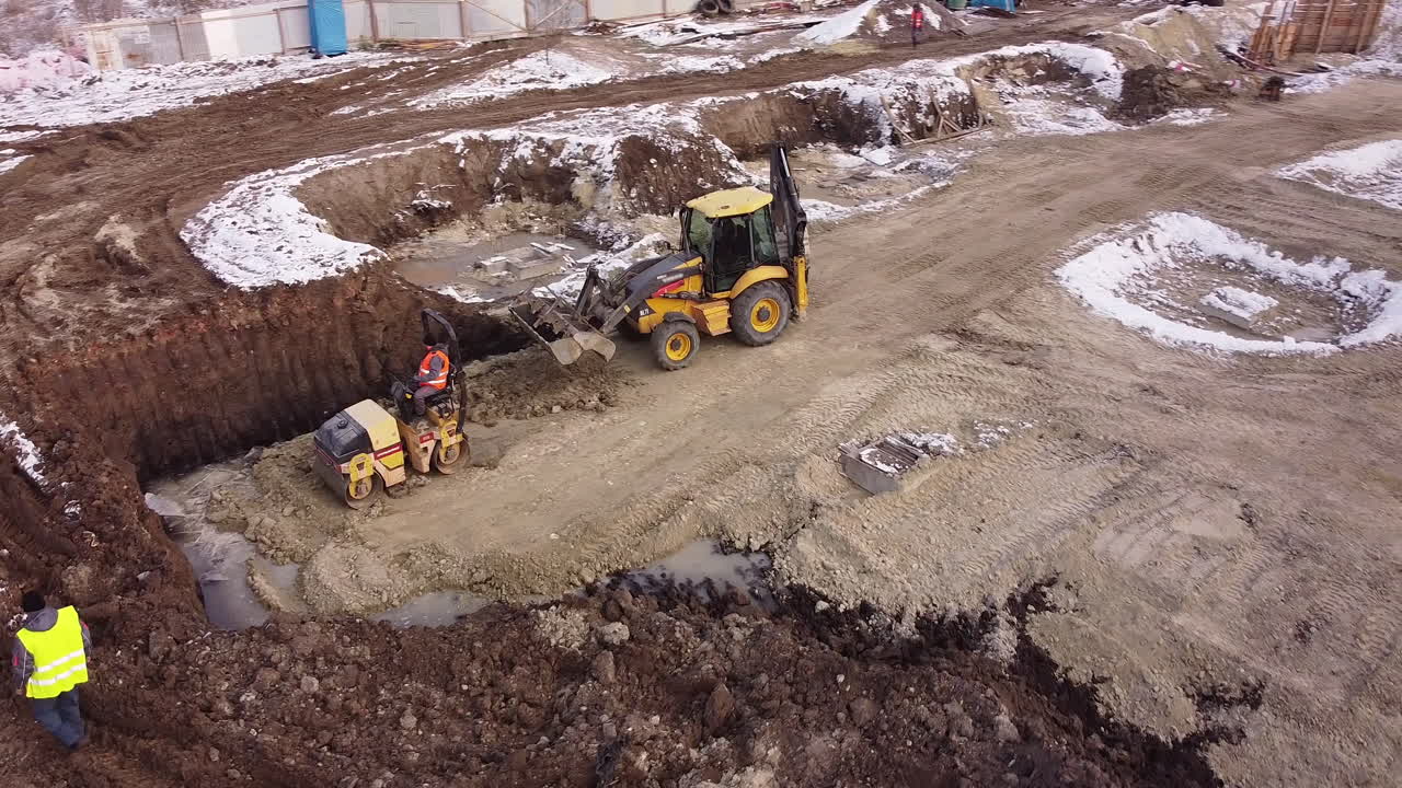 Aerial view of heavy machinery tractor transporting land construction preparation the skating rink