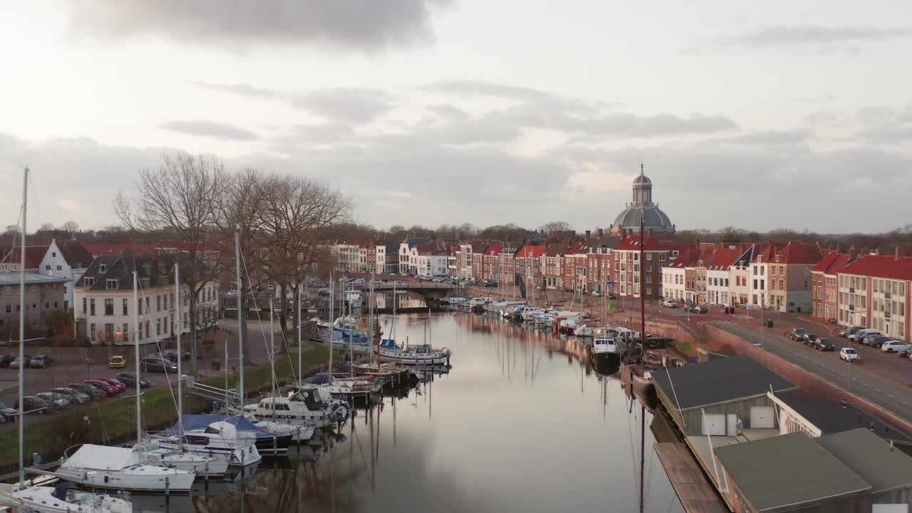 Revealing drone shot of a marina in the historical city Middelburg, during sunset