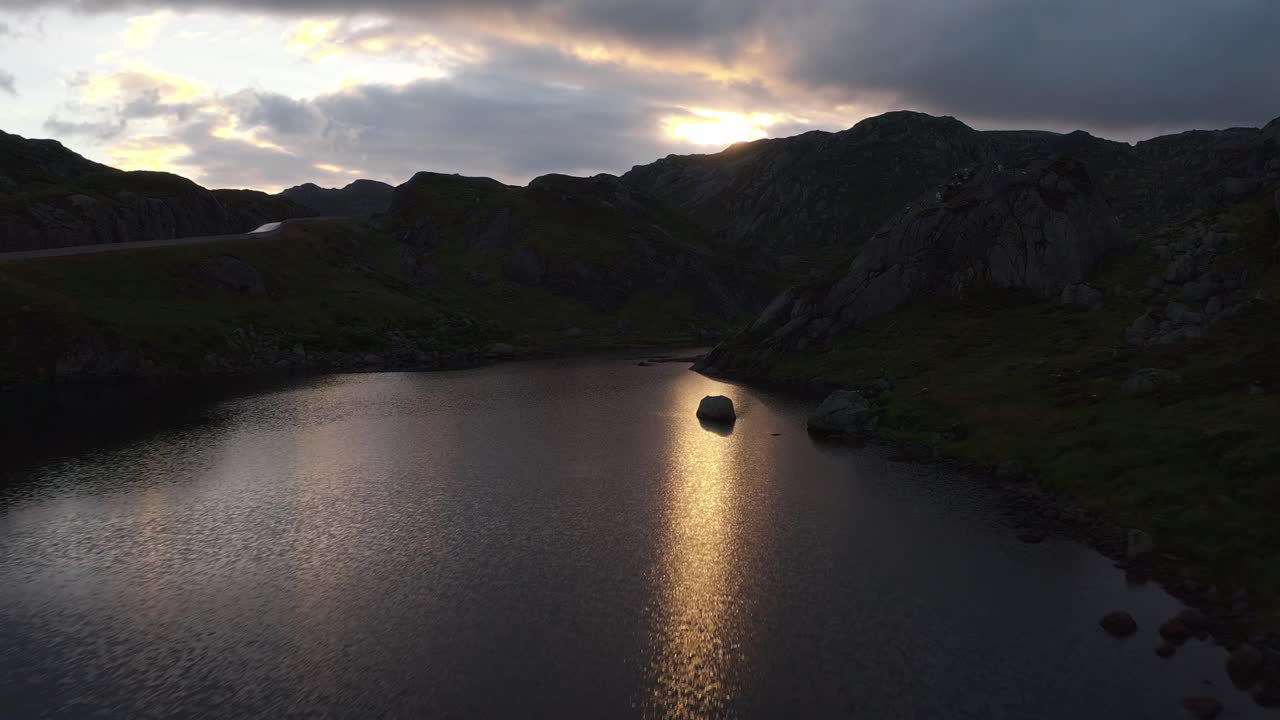 Rocky Norwegian landscape at sunset with calm water reflecting the sky
