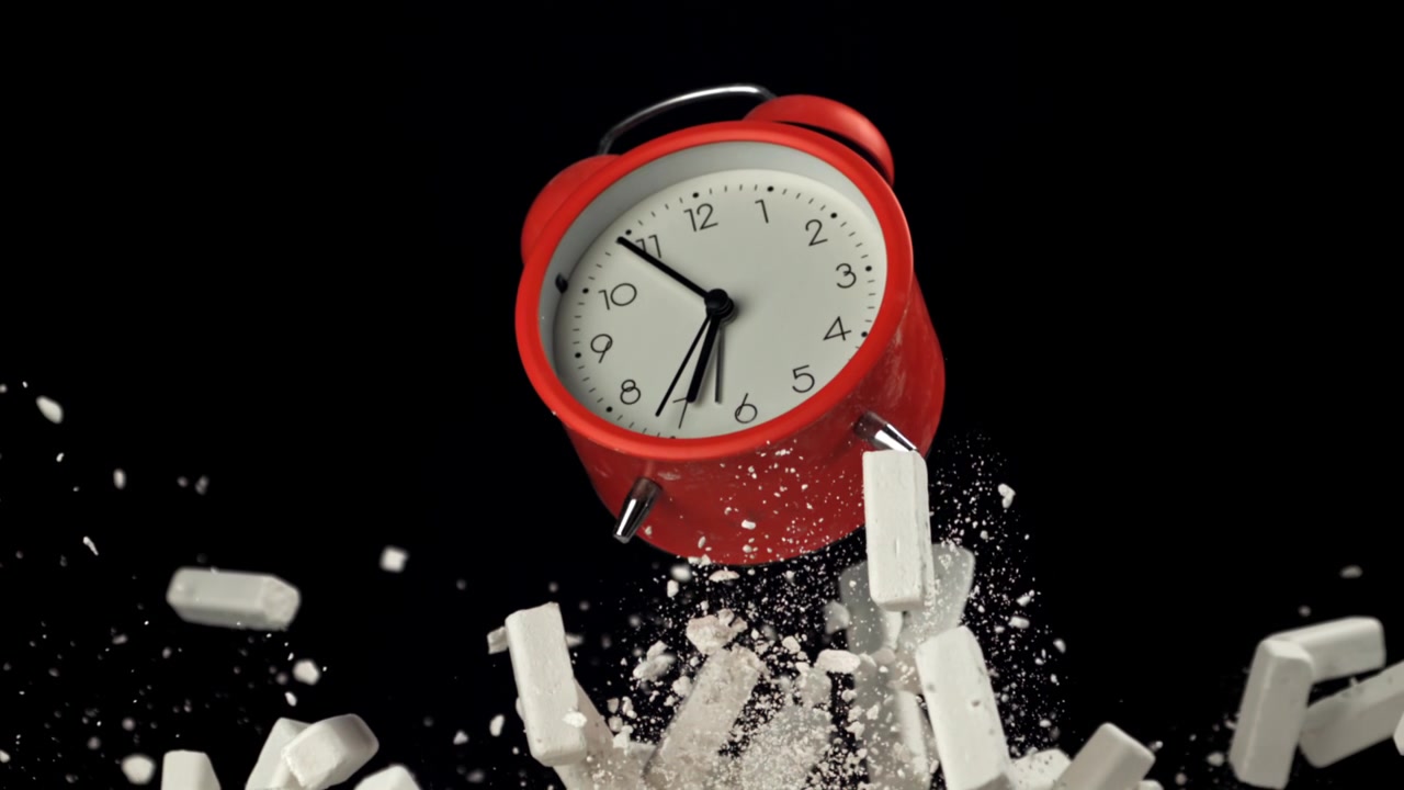 Red Alarm Clock Exploding with Chalk Dust on Black Background