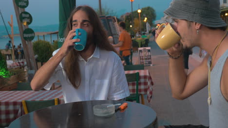 Two-friends-talking-in-cafe-on-waterfront