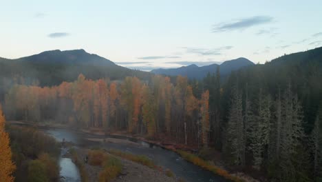 Dolly-In-Aerial-Over-the-Calm-River-and-Colorful-Forest-Through-Morning-Mist-in-Washington-State