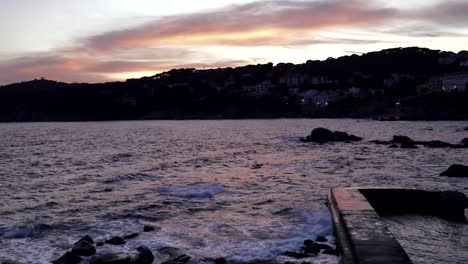 Muelle-Estrecho-A-La-Luz-Del-Atardecer-Rodeado-De-Olas-Espumosas