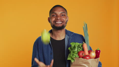 Cheerful-person-juggling-with-a-green-ripe-apple-on-camera