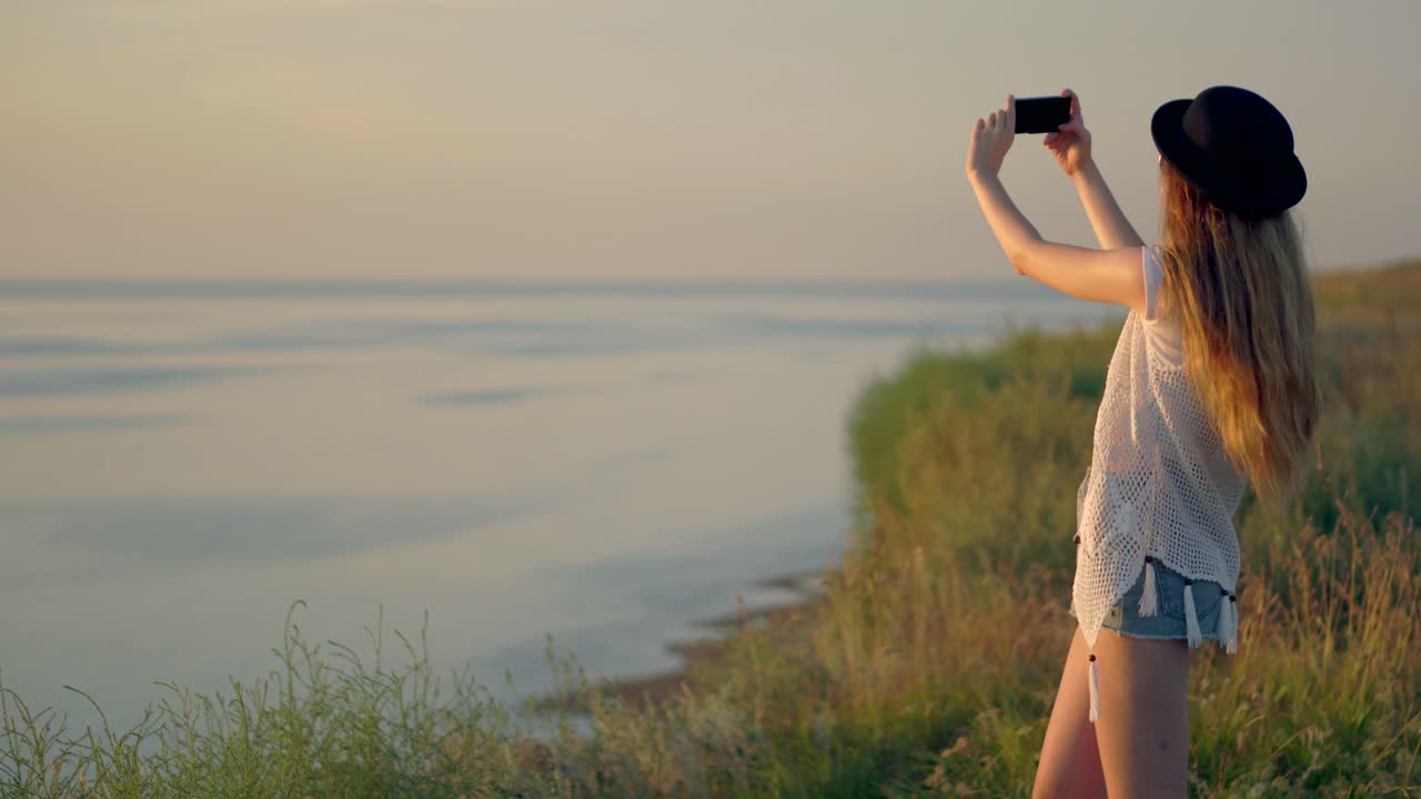 mujer tomando una selfie al atardecer junto al río