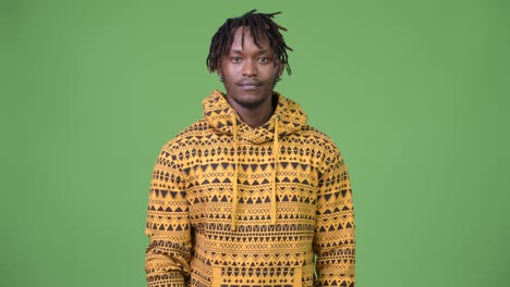 joven y guapo hombre africano contra un fondo verde
